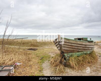 Abgebrochene Fischerboot auf Bank von Meer. Morgen stille Bucht innerhalb windstill. Dramatische und malerische Szene. Dark Sky in Wasser spiegel Stockfoto