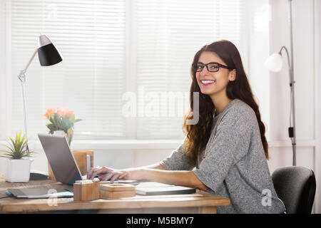 Porträt eines lächelnden jungen Frau am Arbeitsplatz im Büro Stockfoto