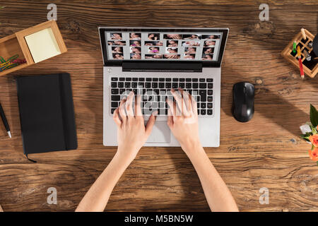 Designer Arbeiten am Laptop Mit vieler Frauen Bilder auf dem Bildschirm am Arbeitsplatz Stockfoto