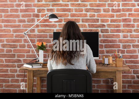 Rückansicht einer Frau mit Computer Stockfoto