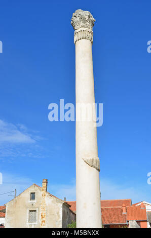 Eine rekonstruierte hohe römische Säule mit einer korinthische Kapitell aus einem zerstörten Tempel mitten in einer Stadt Stockfoto