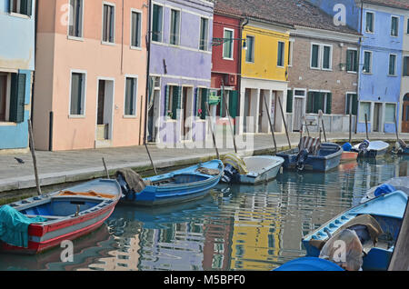 Boote in einem Kanal und bunten Häusern auf die hübsche kleine Insel Burano in der Lagune von Venedig Stockfoto