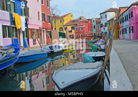 Boote in einem Kanal umgeben von bunten Häusern auf der Insel Burano, in der Lagune von Venedig, Italien Stockfoto