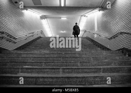 Ein Mann die Treppe hinauf in eine U-Bahn Station Stockfoto