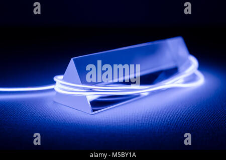 Ein Studio Still life Foto von einem dreieckigen Glasprisma mit abstrakten Neon Beleuchtung in Lila Stockfoto