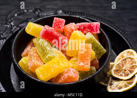 Gelee gummy candy Stücke in dunklen Schale auf einem Holztisch Stockfoto