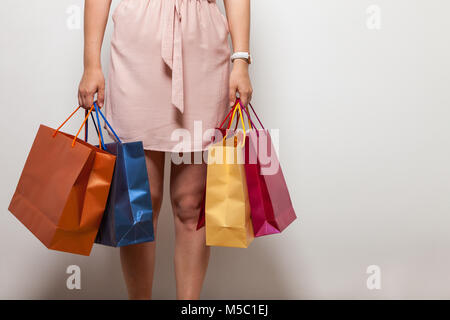 Schöne Frau in rosa Kleid trägt Farbe Beutel mit Lebensmitteln Stockfoto