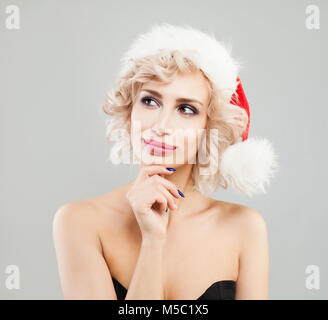 Schöne Weihnachten Frau denken. Glückliche Frau tragen Santa Hut Stockfoto