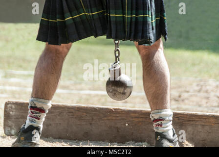 Schottische Person mit Kilt und Metal Ball zwischen seinen Beinen Stockfoto