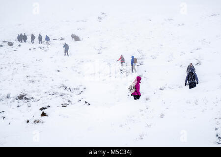 Gruppe der Wanderer Wandern im Schnee auf Moorland während eines Schneesturms im Winter, Kinder Scout, Derbyshire, Peak District, England, Großbritannien Stockfoto