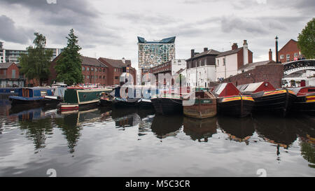 Birmingham, England, UK - 23. Juni 2012: Traditionelle narrowboats und Lastkähne sind im Regency Wharf auf der Birmingham Canal festgemacht, mit dem Würfel bei Mail Stockfoto