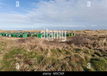 Die fishermens Hütten am South Gare, Redcar, England, Großbritannien mit Offshore- Windenergieanlagen im Hintergrund Stockfoto