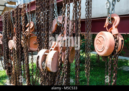 Altes rostiges Metall hoist Kette und Riemenscheibe - Mehrere alte industrielle Kette und Riemenscheibe Stockfoto