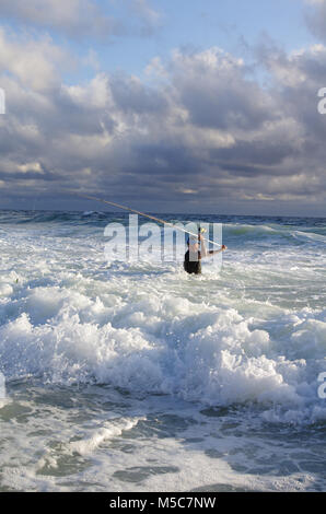 Surf Fischer in die Wellen. Angeln Szene. Surf Casting. Stockfoto