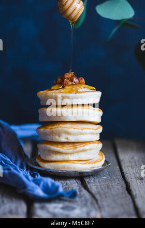 Stapel Pfannkuchen mit Honig und Nüssen. Stockfoto