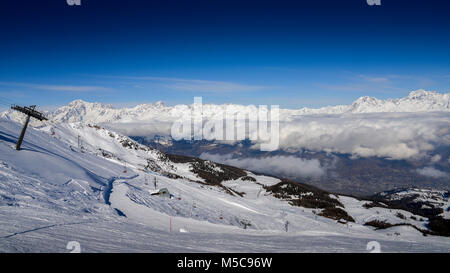 Sesselbahn am italienischen Skigebiet Pila auf schneebedeckten Alpen und Pinien im Winter mit Mt. Blanc in Frankreich im Hintergrund sichtbar Stockfoto