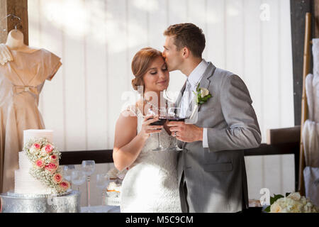Neu Paar küssen während Toast bei einer Hochzeit Heiraten Stockfoto