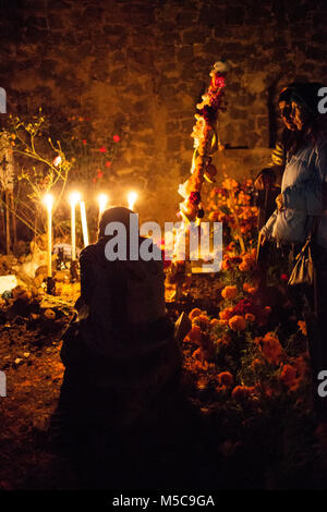 Leute schauen auf dekorierten Gräber auf der Insel Janitzio während Dia de los Muertos (Tag der Toten) feiern in See Patzcuaro, in der Nähe von Patzcuaro, Michoacán, Mexiko am Samstag, 1. November 2014. Dia de los Muertos (Tag der Toten) ist ein traditionelles Urlaub um erinnern und würdigt verstorbenen Familienmitglieder zentriert. Weit davon entfernt, eine düstere Angelegenheit, Dia de los Muetros ist eine Feier des Lebens. Patzcuaro, einer malerischen Stadt im Bundesstaat Michoacán, Mexiko (sieben Stunden westlich von Mexiko Stadt), zieht Touristen aus der ganzen Welt in den Tagen vor dem Dia de los Muertos. Stockfoto