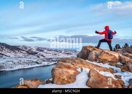 Männliche Wanderer betrachten winter Sonnenaufgang über gefrorene Horsetooth Reservoir an der felsigen Berge Voralpenland in der Nähe von Fort Collins, Colorado Stockfoto