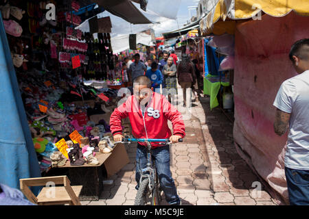 Ein Junge fährt mit dem Fahrrad durch einen Markt im Herbst Fiesta in Cheran, Michoacán, Mexiko am Sonntag, 5. Oktober 2014. Die Stadt Cheran hält jährlich zwei Fiestas, die ihre Kultur und religiösen Überzeugungen zu feiern. Im April 2011, nach Jahren der Erpressung durch die Kartelle und Selbstgefälligkeit der lokalen Regierung und der Polizei, die Leute von Cheran, ihre Stadt und ihr Land zurück. Das Pueblo (als Menschen oder Gemeinschaft übersetzt) Das Kartell konfrontiert, entfernt die Regierung aus dem Amt, und erstellt ihre eigene Polizei, um die Stadt zu schützen. Stockfoto