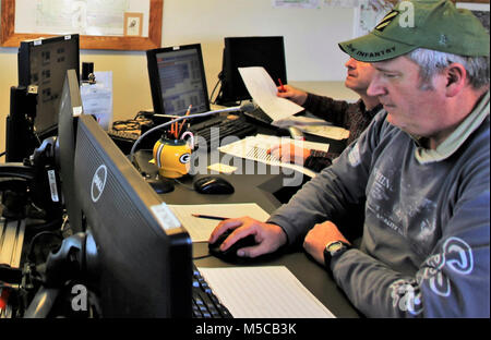 Bereichsschaltung Techniker Mark Rücksprache mit der Direktion der Pläne, Ausbildung, Mobilisierung und Sicherheit arbeitet am Feuer Schreibtisch am 31.01.16, 2018, am Fort McCoy, Wis. Der Schreibtisch betreibt die Kommunikation mit Einheiten, die mit Hilfe der Strecke Komplex sowie Bereich Wartung und anderen Personals über 46.000 Hektar Ausbildung Bereiche auf Fort McCoy. (U.S. Armee Stockfoto