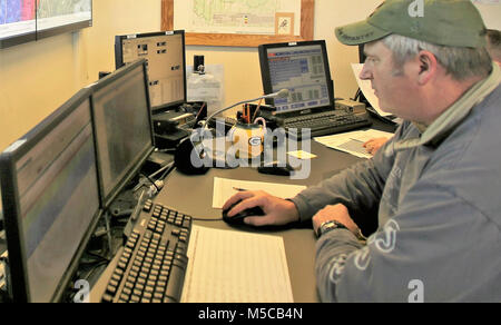 Bereichsschaltung Techniker Mark Rücksprache mit der Direktion der Pläne, Ausbildung, Mobilisierung und Sicherheit arbeitet am Feuer Schreibtisch am 31.01.16, 2018, am Fort McCoy, Wis. Der Schreibtisch betreibt die Kommunikation mit Einheiten, die mit Hilfe der Strecke Komplex sowie Bereich Wartung und anderen Personals über 46.000 Hektar Ausbildung Bereiche auf Fort McCoy. (U.S. Armee Stockfoto