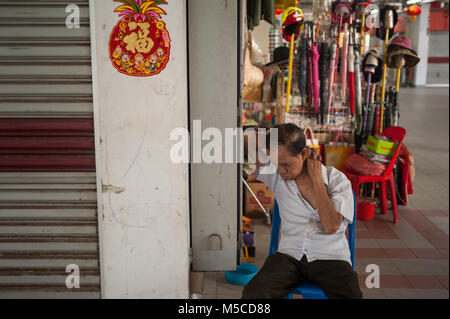 19.02.2018, Singapur, Republik Singapur, Asien - in Singapur Chinatown ein älterer Mann sitzt auf einem Stuhl in der Chinatown komplexe Einkaufszentrum Stockfoto