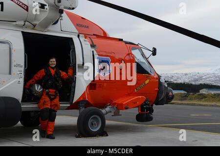 Petty Officer 2nd class Eileen am Besten, ein Aviation Maintenance Technician, steht neben einem MH-60 Jayhawk Helikopter bei Coast Guard Air Station Kodiak, Alaska, 13.02.2018. Am besten hat einen Flug Mechaniker für mehr als ein Jahr gewesen und ist ihre zweite Tour in Kodiak dienen. Us-Küstenwache Stockfoto