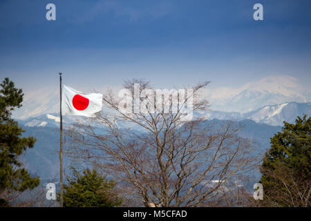 Eine japanische Flagge in der Nähe von Takayama von Bergen bedeckt mit Schnee umgeben. Stockfoto