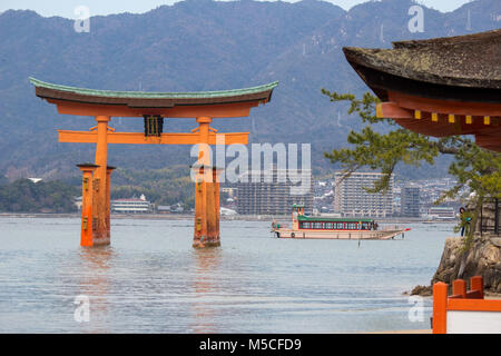 Itsukushima, auch als Miyajima bekannt, ist eine kleine Insel in der Bucht von Hiroshima. Nur offshore ist der Riese, orange Große Torii Tor. Stockfoto