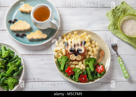 Lustig Löwe Essen Gesicht mit Schnitzel, Pasta und Gemüse Stockfoto