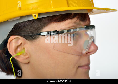 Frau mit schützenden Ohrstöpsel und Helm. Stockfoto