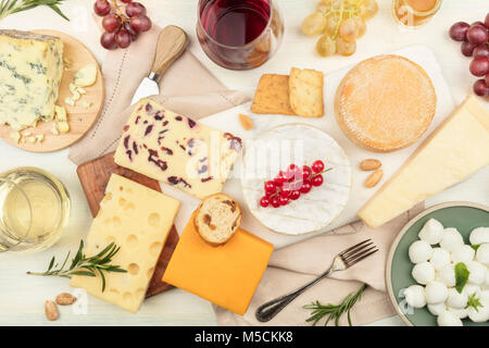 Verschiedene Arten von Käse mit Wein auf einem hellen Hintergrund Stockfoto