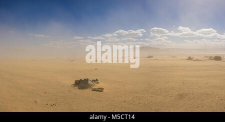 Stein ring bildet eine Feuerstelle in einer riesigen sandwüste unter der Wolke eines wachsenden Sandsturm. Stockfoto