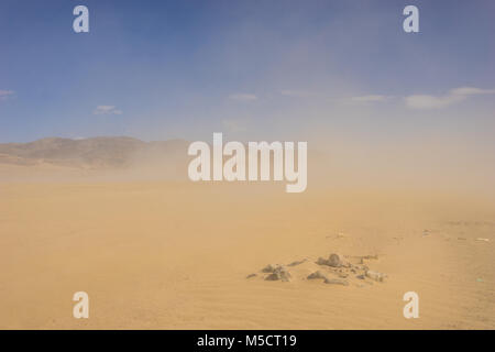 Wolken von Sand Schlag um die Felsen in der Mitte eines riesigen sandwüste. Stockfoto