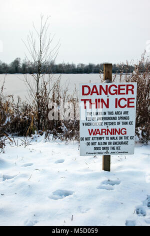 Gefahr: Dünnes Eis Warnschild an einem zugefrorenen See bei Neighbridge Country Park in der Nähe von somerford Keynes in der Costwold Water Park Stockfoto