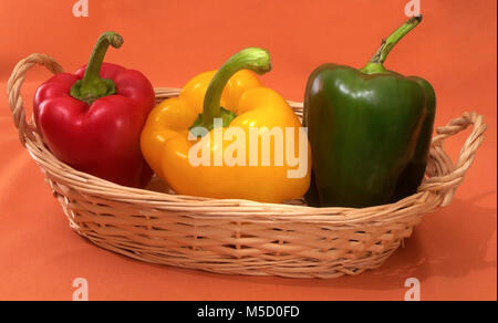 Kleine Weidenkorb mit drei bunten Paprika, Andalusien, Spanien, Europa Stockfoto