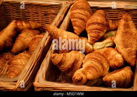 Puffy golden braun Croissants im Vertrieb Weidenkörbe, frisch gebackene, mit natürlicher Beleuchtung Stockfoto