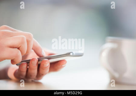 Zugeschnittenes Bild bei der Verwendung von Smart Phone im Büro Schreibtisch Geschäftsfrau Stockfoto