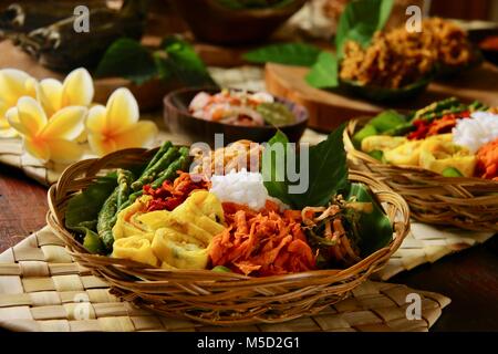 Nasi Campur Bali. Beliebte traditionelle balinesische Gericht aus gedämpftem Reis mit verschiedenen Beilagen serviert. Stockfoto