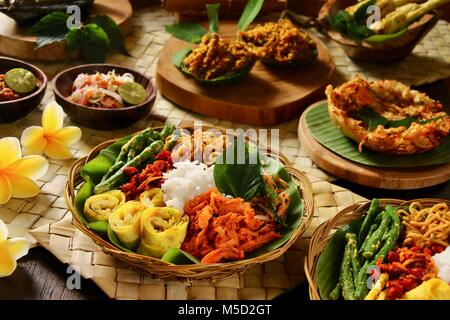 Nasi Campur Bali. Beliebte traditionelle balinesische Gericht aus gedämpftem Reis mit verschiedenen Beilagen serviert. Stockfoto