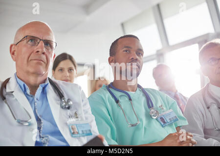 Aufmerksame Chirurgen, Ärzte und Krankenschwestern in der Sitzung hören Stockfoto
