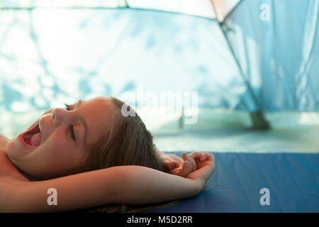 Müde Mädchen gähnen, Ruhe im Zelt Stockfoto