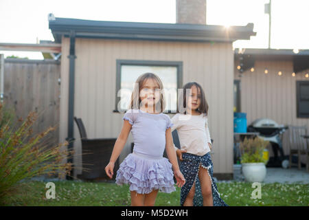 Portrait Mädchen Schwestern in Röcken in Hof Stockfoto