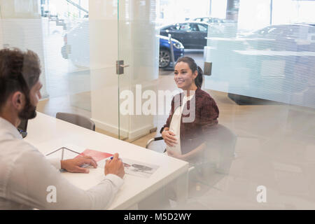 Autoverkäufer zu sprechen schwangere Kunde im Autohaus Büro Stockfoto