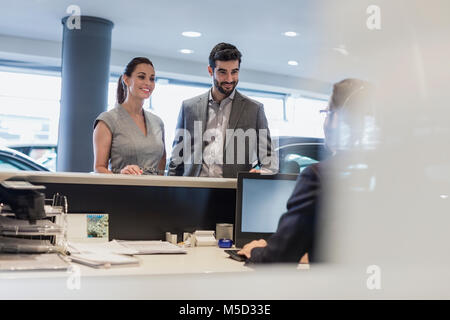 Paar an der Rezeption im Auto Dealership showroom Stockfoto