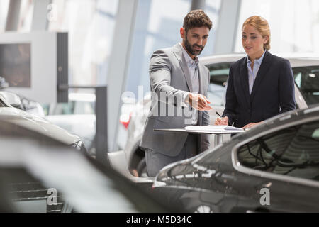 Auto Verkäufe Leute treffen, prüft neue Auto Auto Dealership showroom Stockfoto