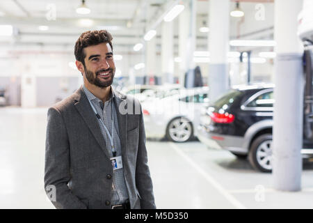 Porträt Lächeln Autoverkäufer weg schauen im Autohaus Werkstatt Stockfoto