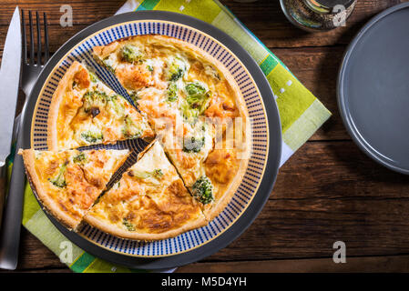 Klassische Lachs und Broccoli Quiche aus mürbteig Gebäck mit Brokkoliröschen und geräuchertem Lachs in einer cremigen freie Strecke Eierstich Stockfoto