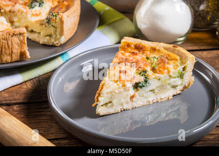 Klassische Lachs und Broccoli Quiche aus mürbteig Gebäck mit Brokkoliröschen und geräuchertem Lachs in einer cremigen freie Strecke Eierstich Stockfoto